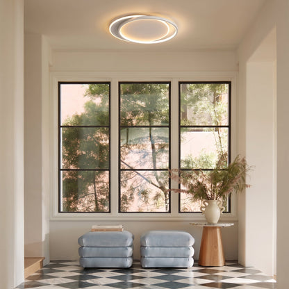 Ring light above a bright entrance with large windows, blue ottomans and a chequered floor 9