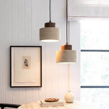 Two lit pendant lights hang beside a window above a marble table and a panelled wall 1