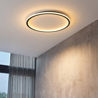 Lit ring ceiling light above a textured plaster wall and sheer curtains beside a window. 3