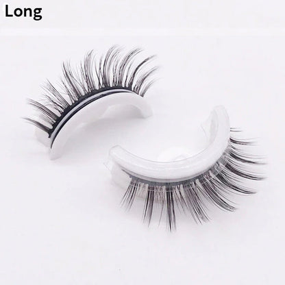 Pair of long, wispy lashes on curved white holders, one upright and one on its side, shown against a plain pale background. 13