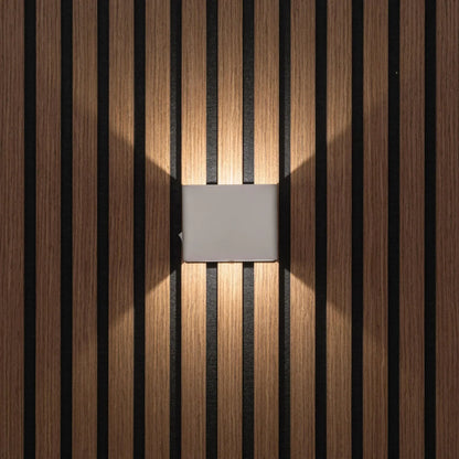 Front view of the light grey cube light casting warm light on a slatted wall 6
