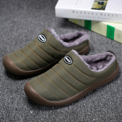 Pair of olive green quilted slippers with grey fleece lining, resting on grey carpet beside books 2