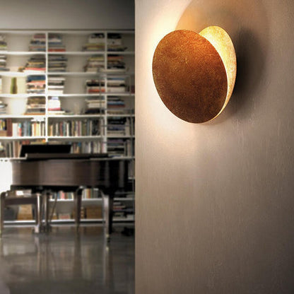 Side view of the lamp on a plain wall, with a bookshelf and piano behind 4