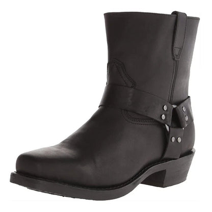 Black version of the harness ankle boot at a three-quarter angle, showing the studded strap, pull loop and square toe. 2