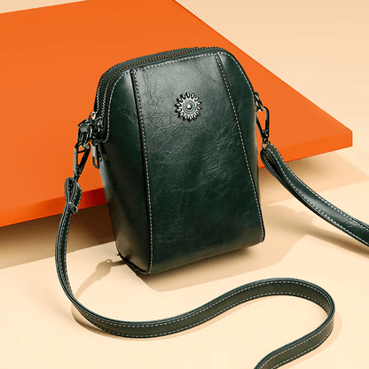 Dark green version at an angle against an orange panel, with its strap looped in front 8