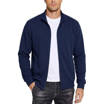 Man wearing the navy blue zip-up jacket open over a white t-shirt, one hand in the pocket, front view. 3