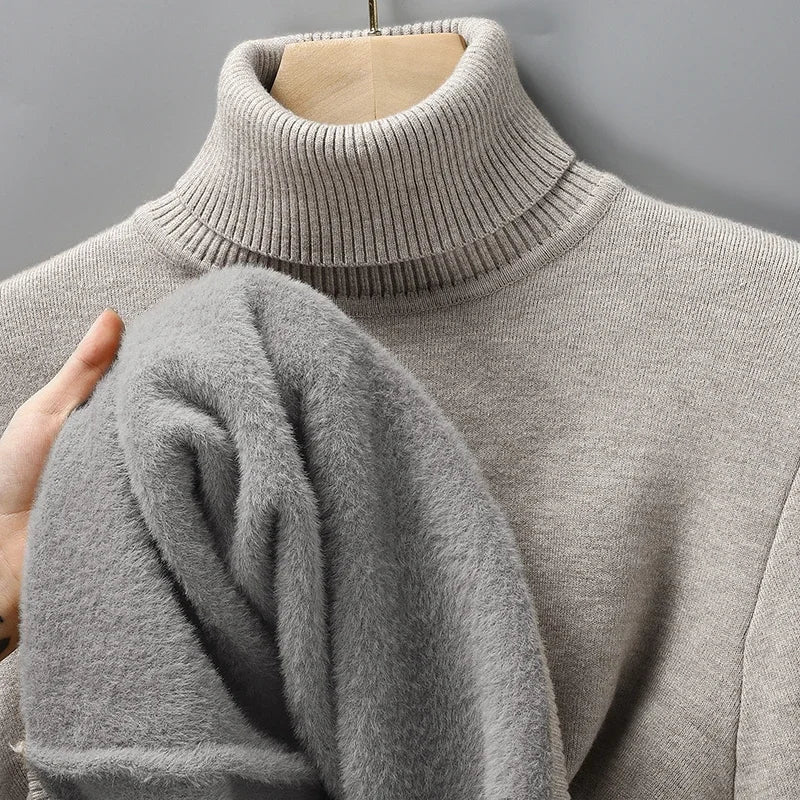 Beige turtleneck jumper on a hanger, with a hand pulling out the soft grey fleece lining 6