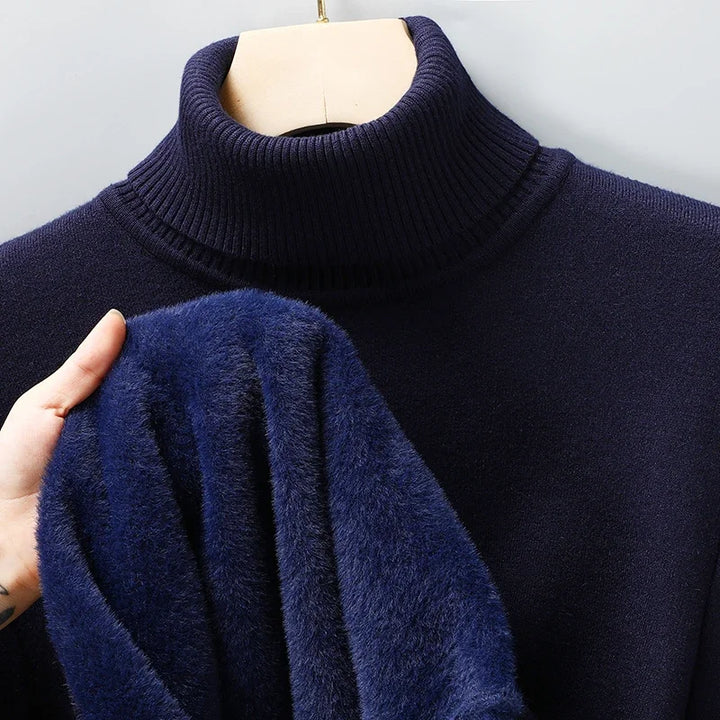 Navy turtleneck jumper on a hanger, with a hand showing the plush blue lining inside 7