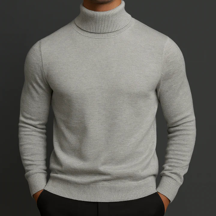 Model wearing a light grey turtleneck jumper with ribbed cuffs and hem, front view 2