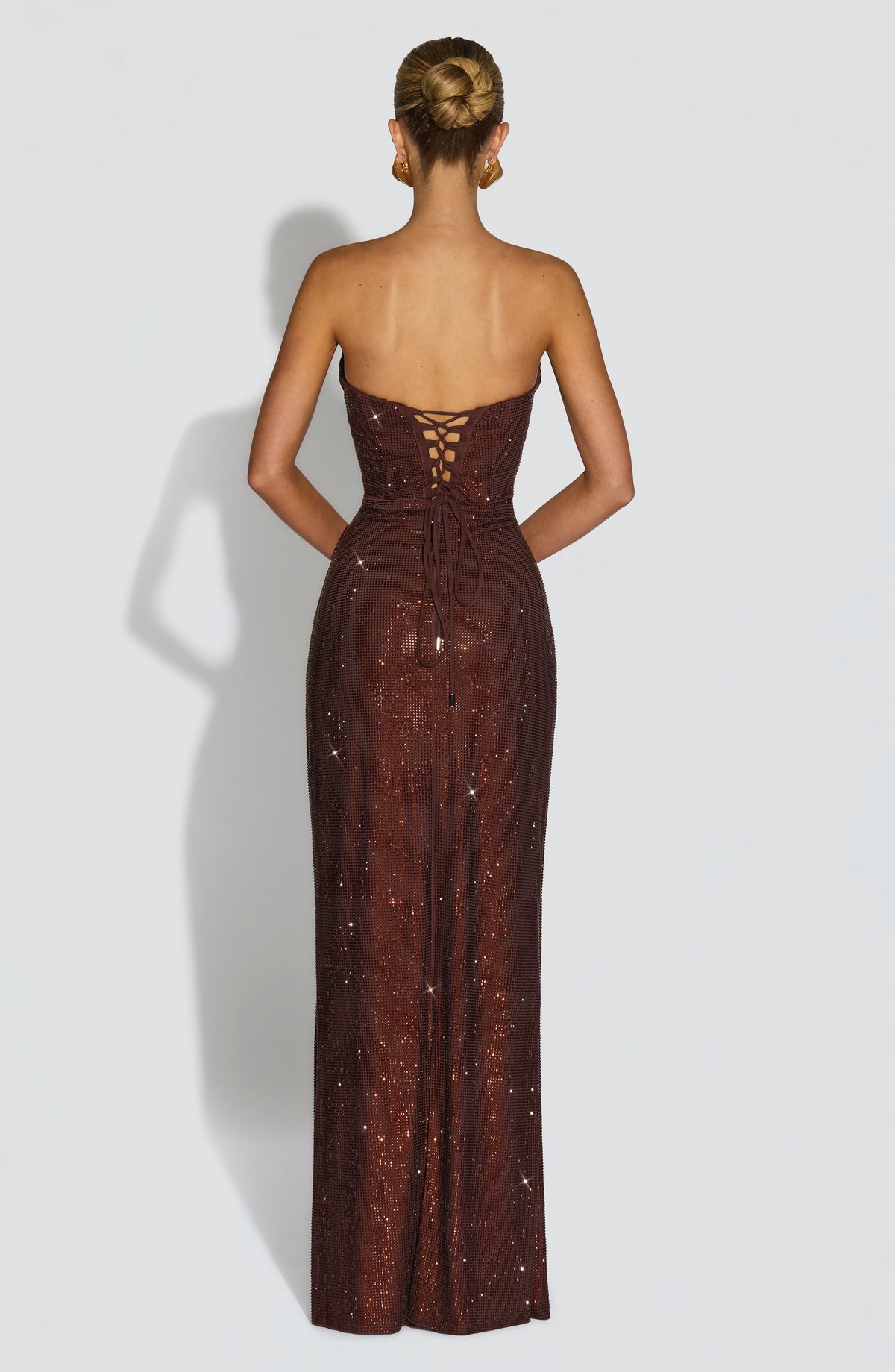 Back of the brown rhinestone dress showing the lace-up corset closure with tie ends hanging down the skirt. 8