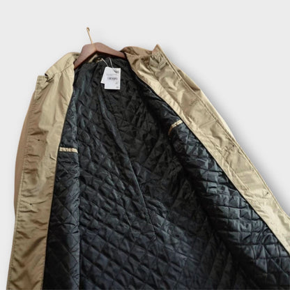 Beige coat on a wooden hanger, opened to show the black diamond-quilted lining and a hanging tag. 6