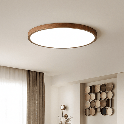 Walnut-toned round light fitted flat to the ceiling of a calm living space with curtains and a wall display of wooden discs. 11