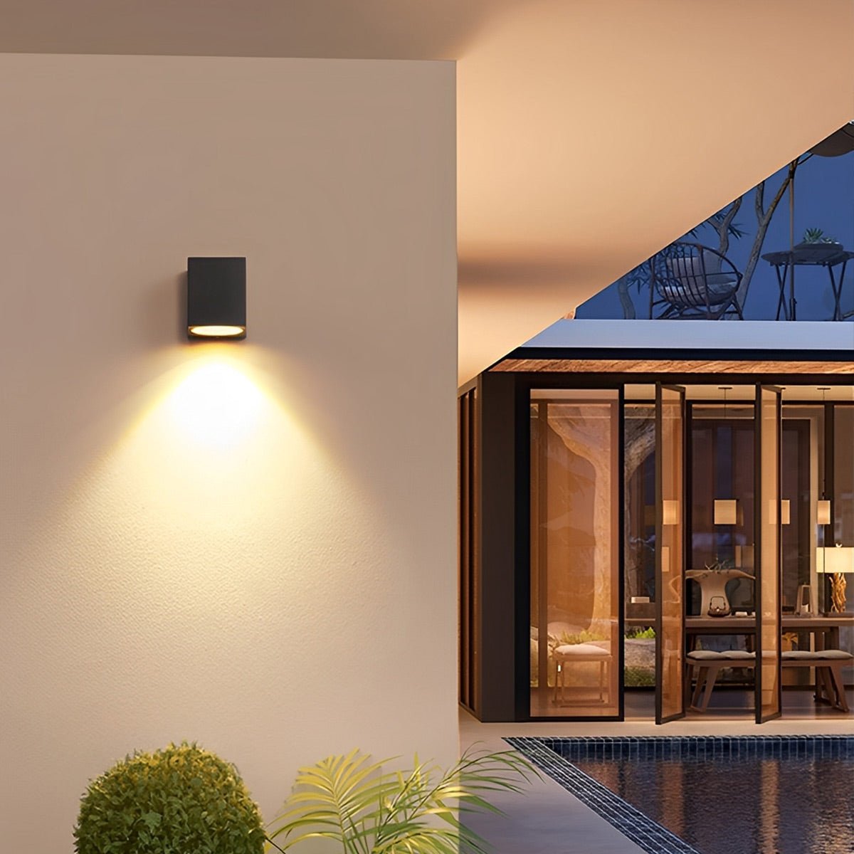 Black rectangular wall light casting a downward beam beside a lit glass-walled terrace and pool 8