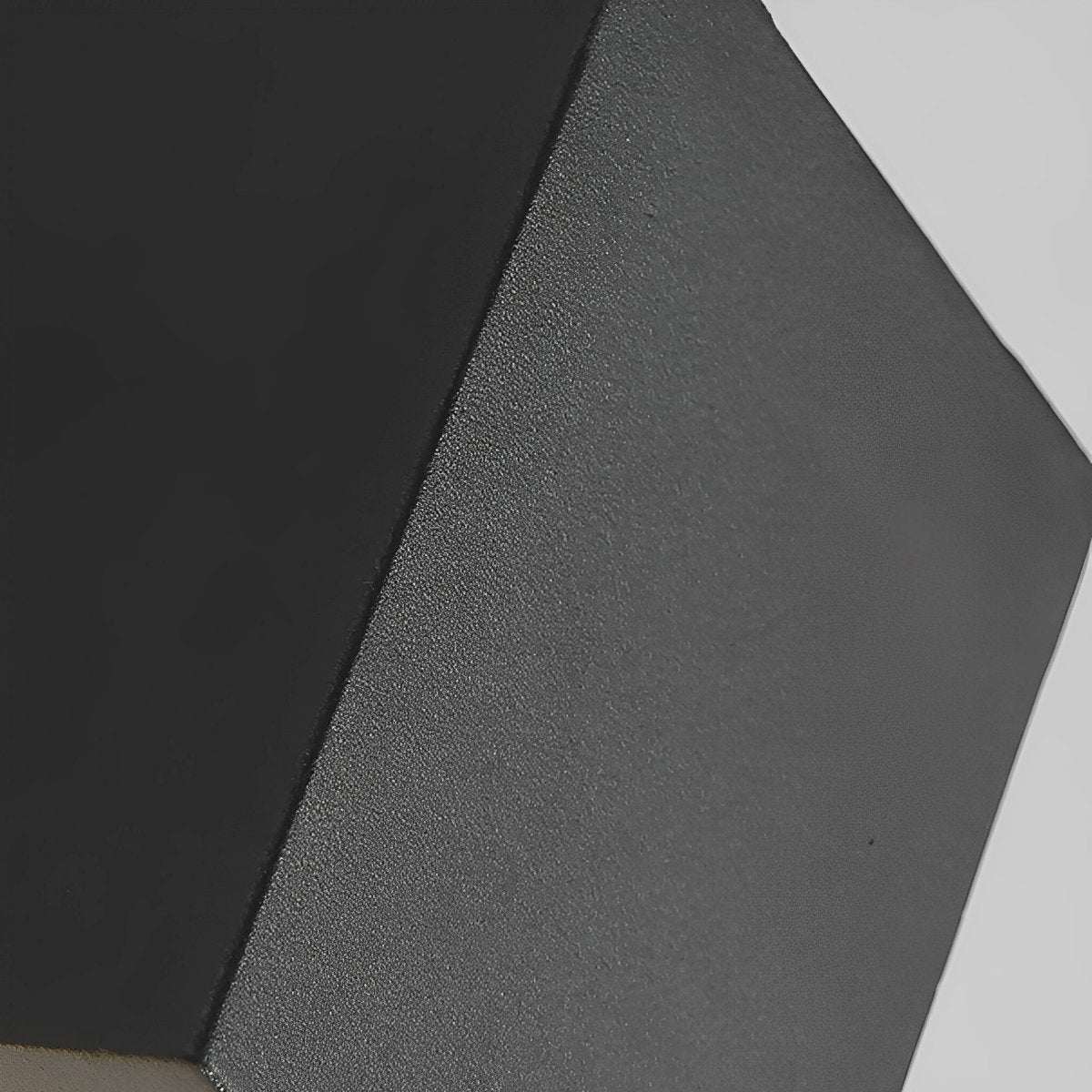 Close-up of the black lamp body's matte, finely textured finish and sharp square edges 14
