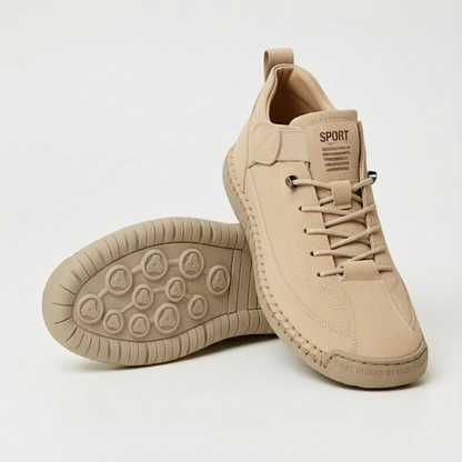 Beige suede-look lace-up trainers, one shoe upright and one on its side showing the studded, ridged tan sole. 1