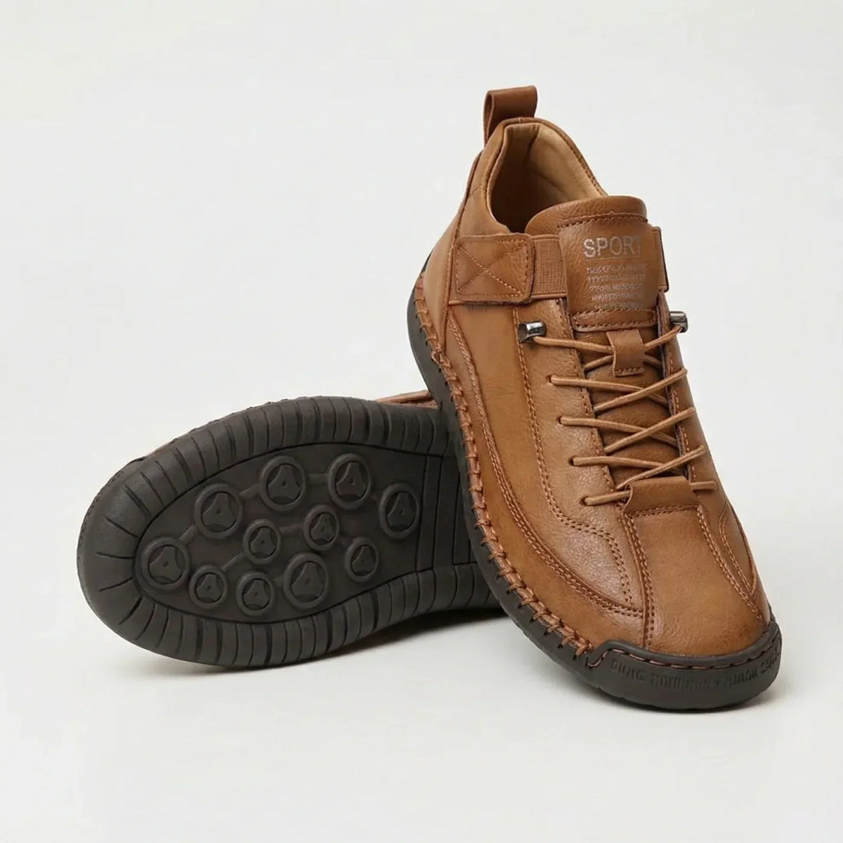 Tan brown leather-look trainers with contrast stitching, one shoe standing and one tilted to reveal the dark brown studded sole. 4