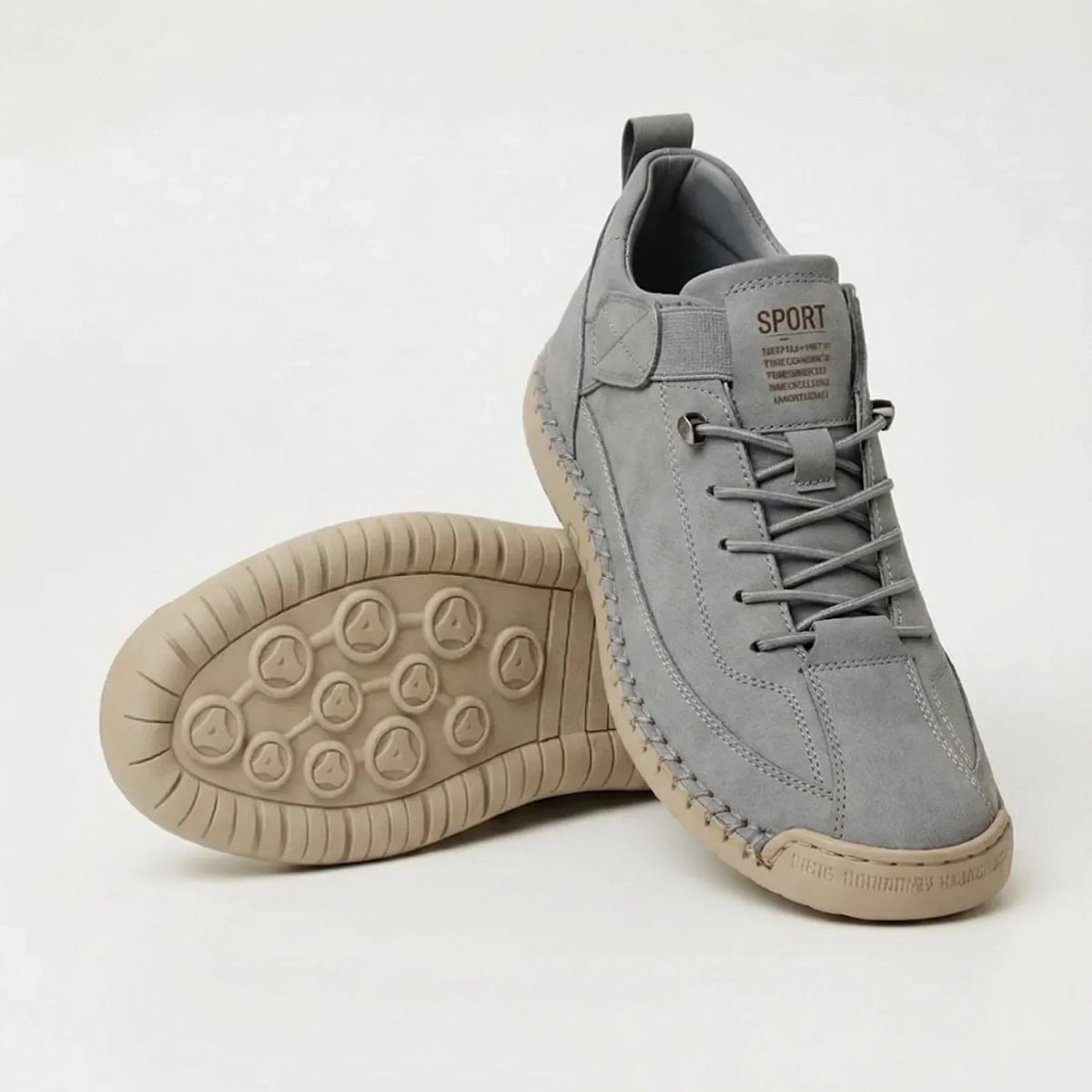 Light grey suede-style trainers with matching laces and a sand-coloured sole, one shoe upright and one showing the studded underside. 8