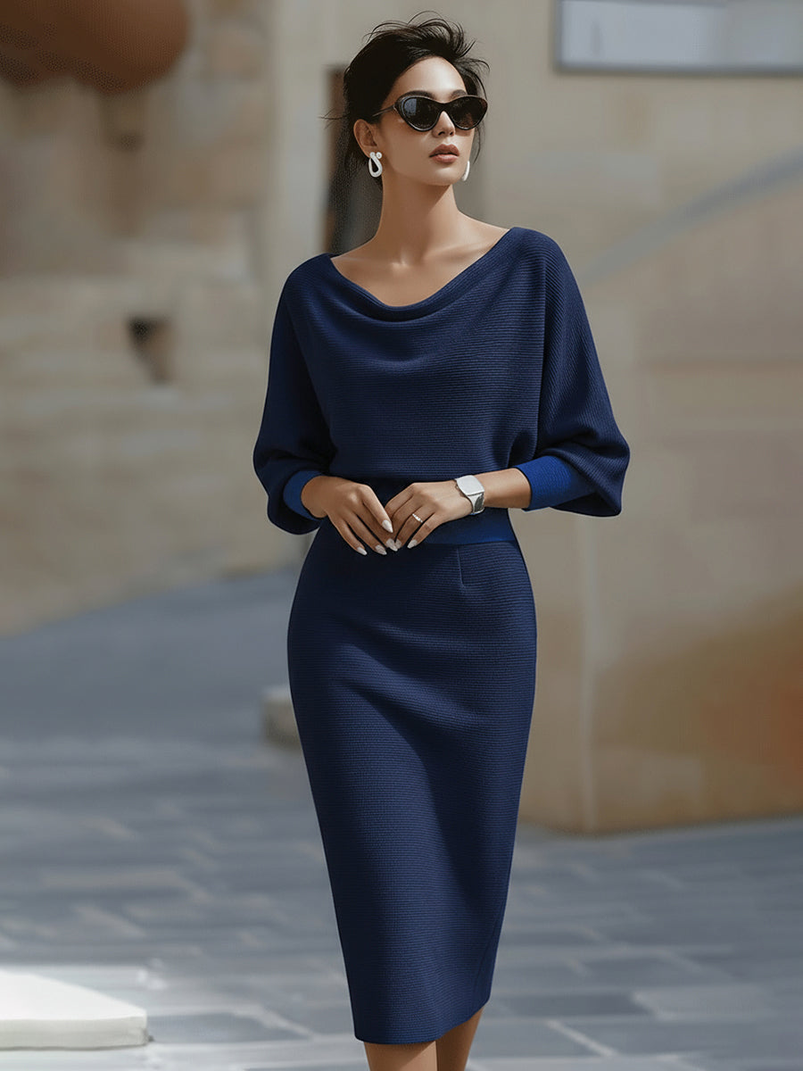 Model in sunglasses wearing the midi dress in navy blue, with contrasting brighter blue cuffs and waistband. 6