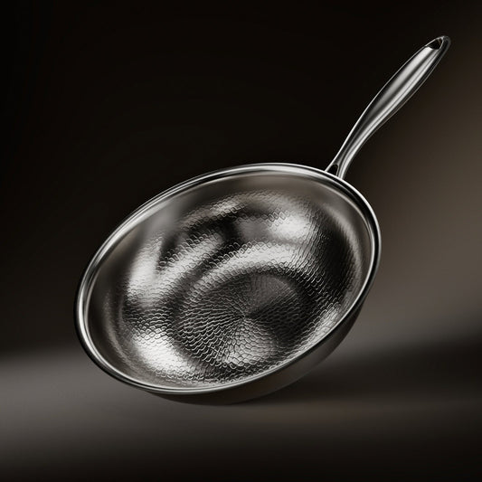 Wok pan tilted on a dark background, showing its hammered, scale-like textured interior and a long polished metal handle. 1