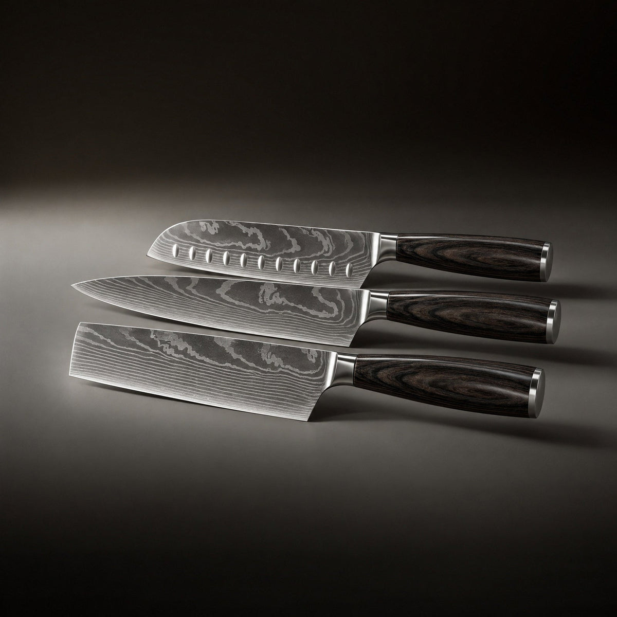 The three knives laid flat side by side, showing the grooved blade, the pointed blade and the rectangular cleaver-style blade. 2
