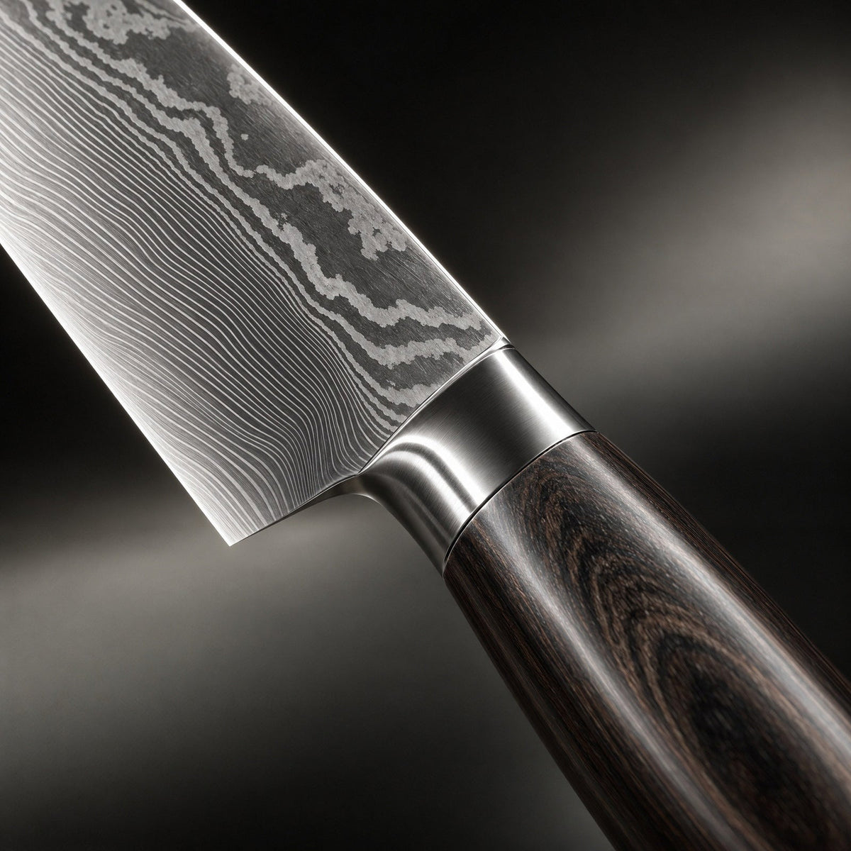 Close-up of one blade's layered steel pattern, its metal bolster and the grained dark wooden handle. 3