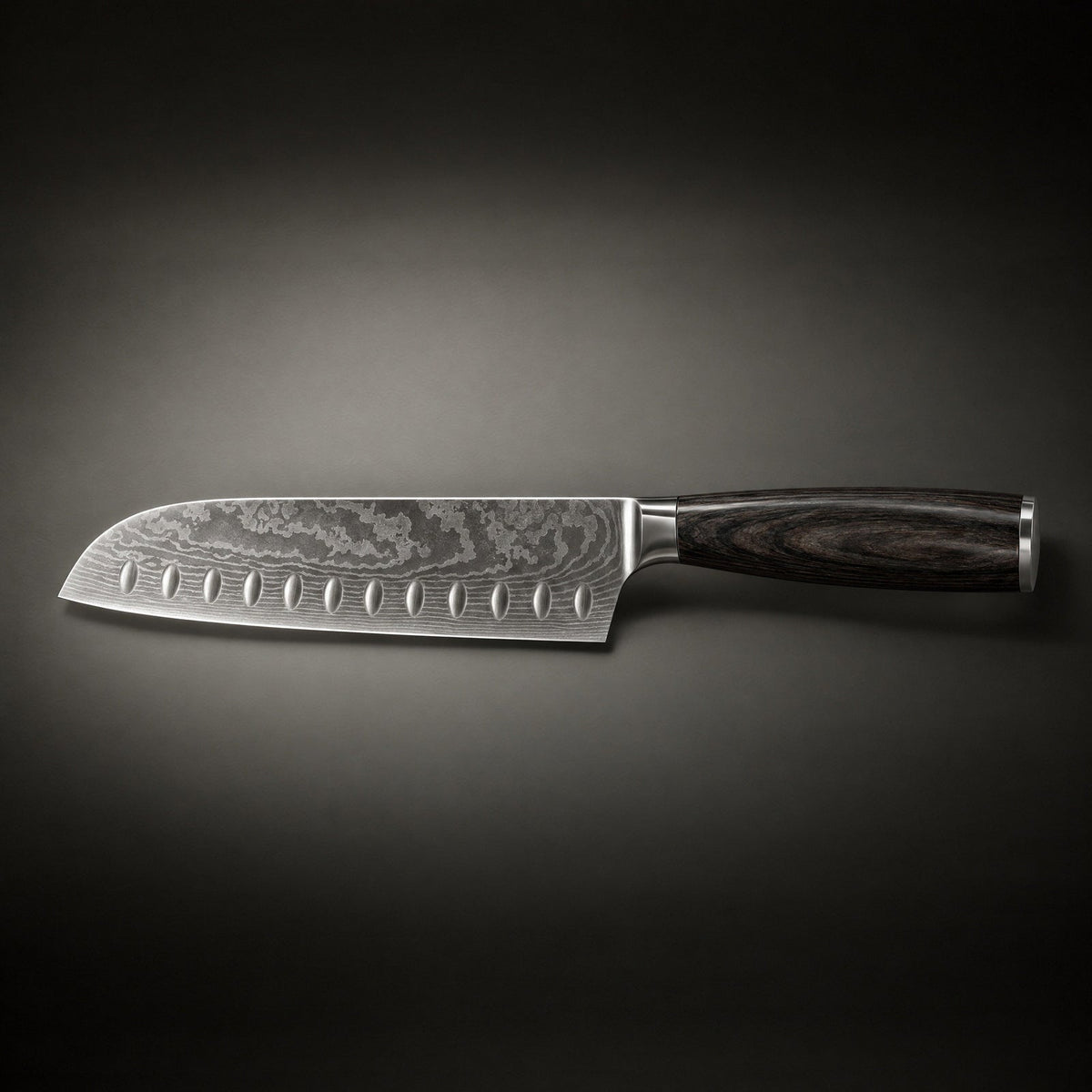 Santoku knife lying horizontally in profile, with a row of hollow indentations and a dark wood handle 2