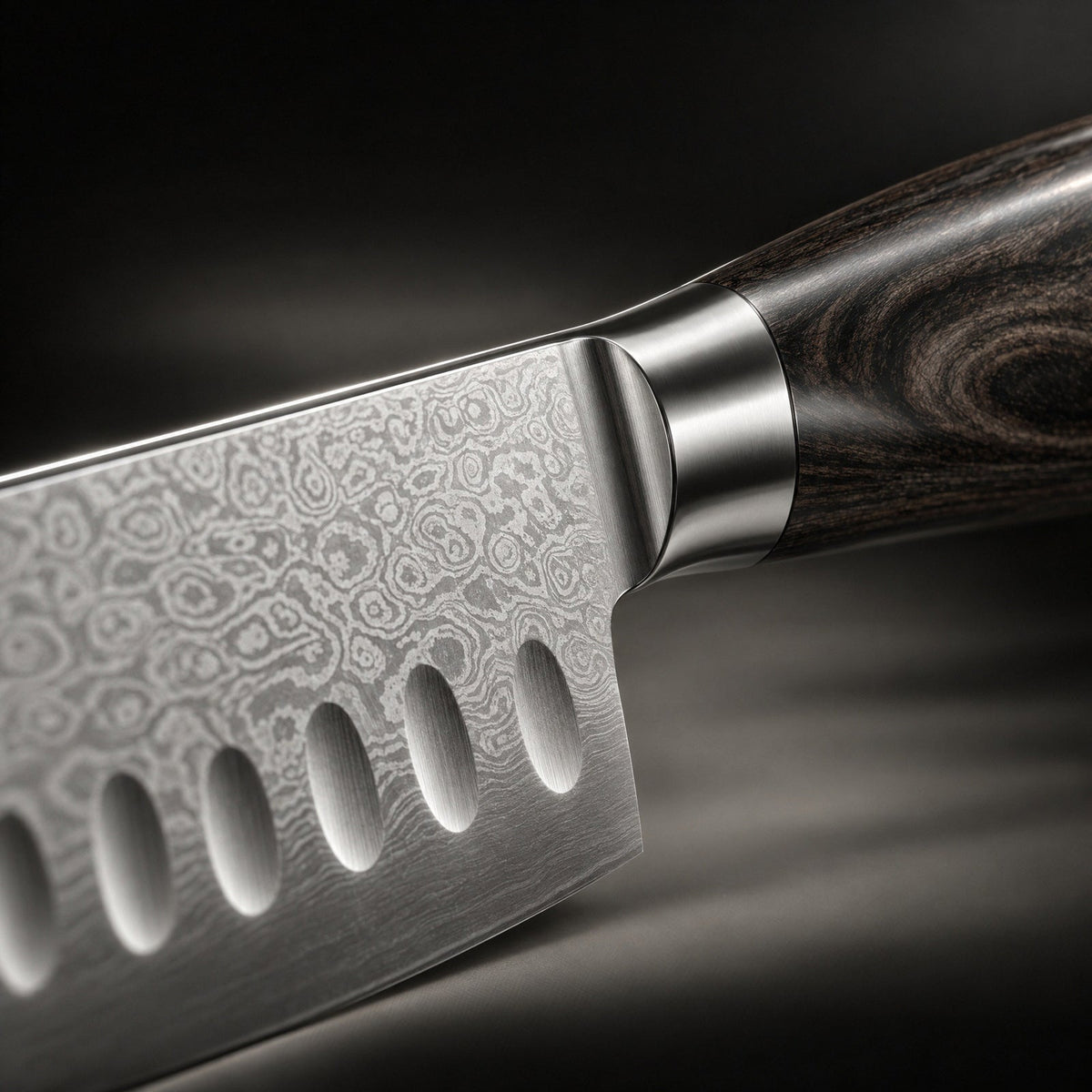 Close-up of the blade heel, steel bolster and dark wood grain, showing the swirling layered-steel pattern 3