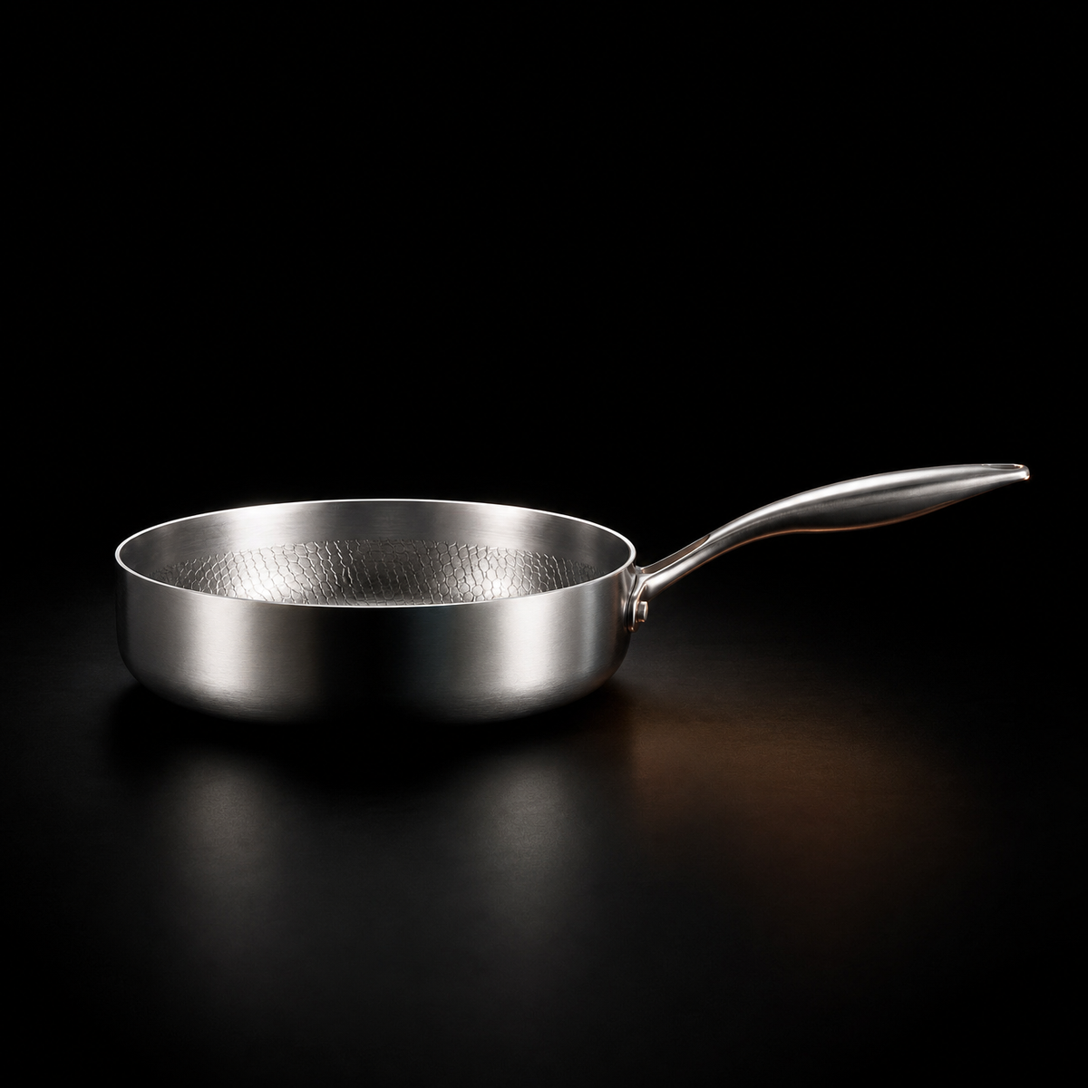Side profile of the pan on a dark background, showing its high straight sides and riveted handle 2