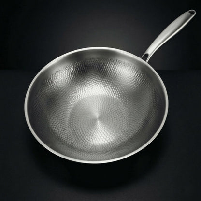 Wok viewed from directly above, showing the hammered scale-like pattern across the whole cooking surface and the steel handle. 2