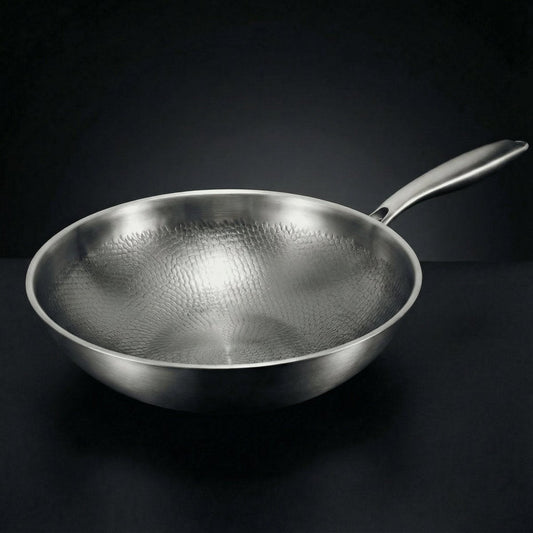 Empty wok seen from a low side angle on a dark surface, showing its hammered interior and long steel handle. 1