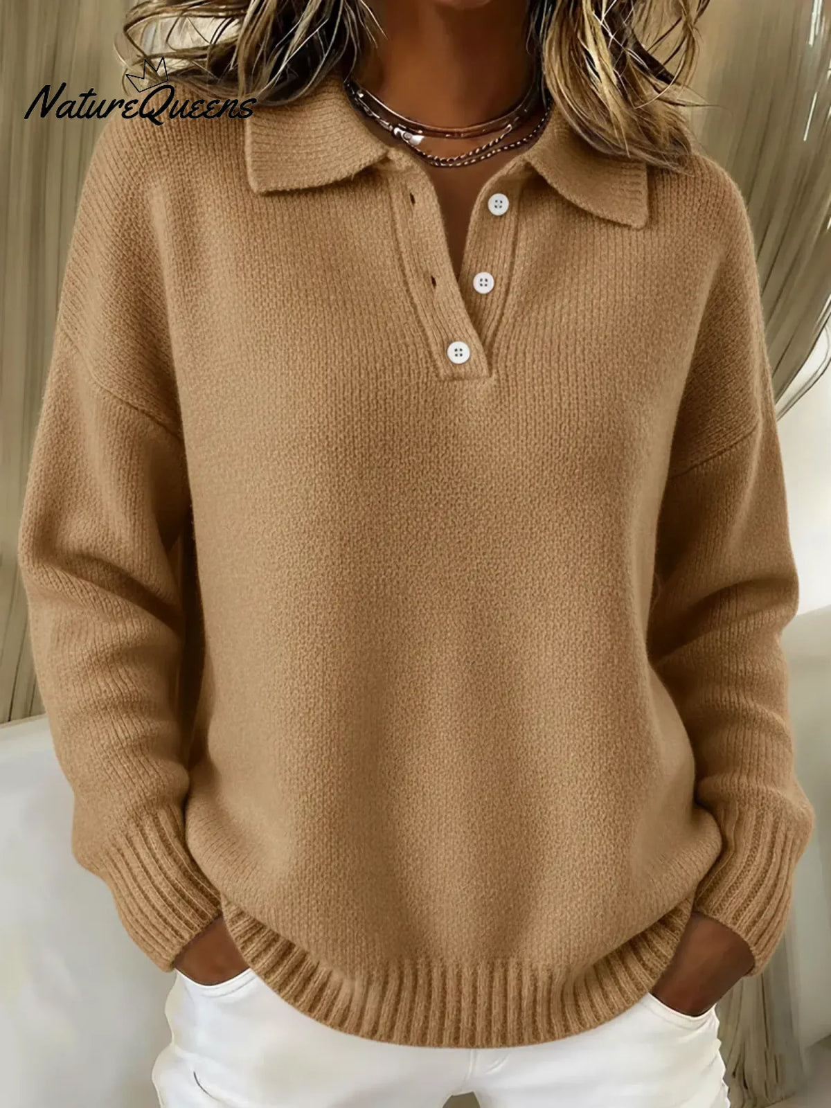 Model wearing the knitted polo jumper in camel tan, with white buttons at the neckline and ribbed hem and cuffs. 4