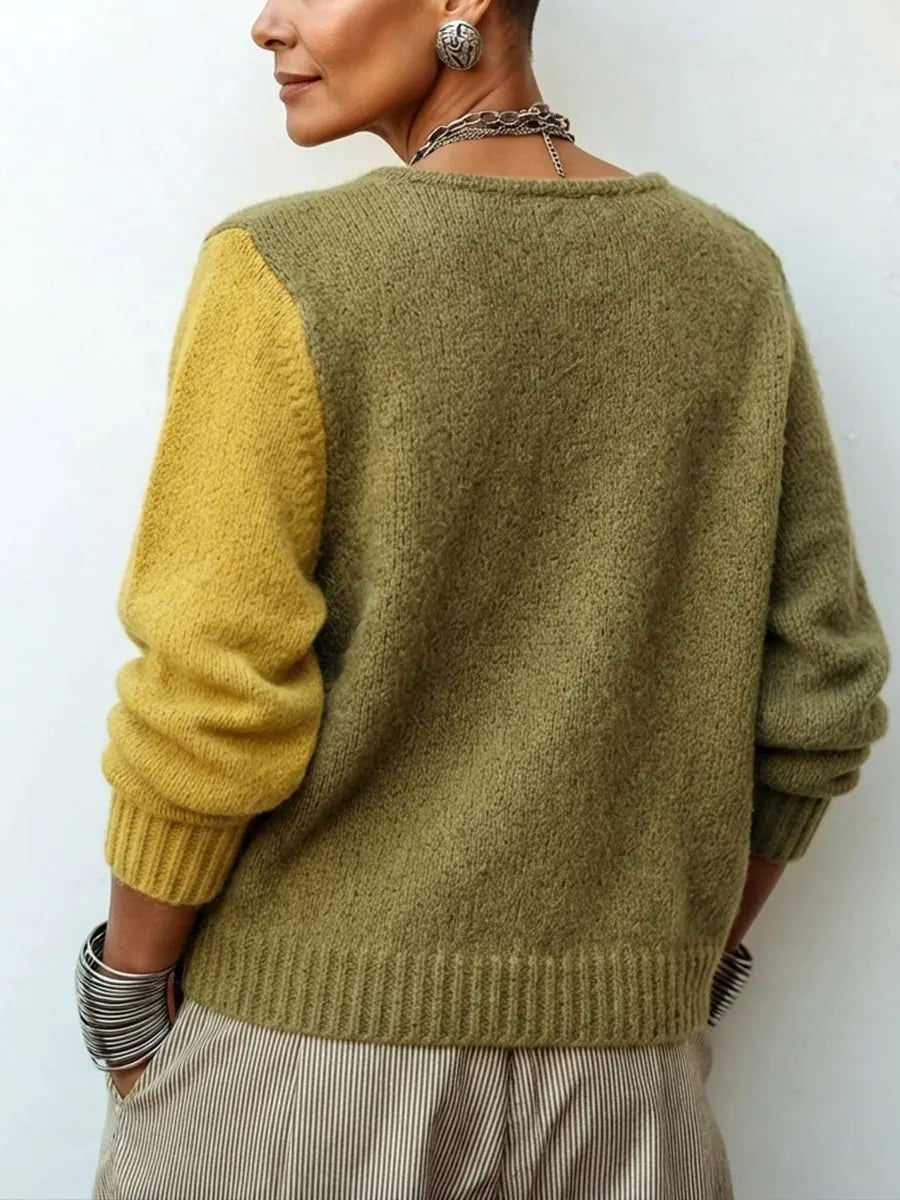 Back view of the knit jumper showing a plain olive back, one mustard sleeve, ribbed hem and cuffs, worn by a model. 2
