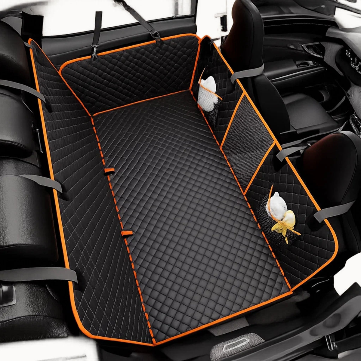 Overhead view of the black diamond-quilted cover with orange edging, grey straps and mesh pockets holding small white items. 8