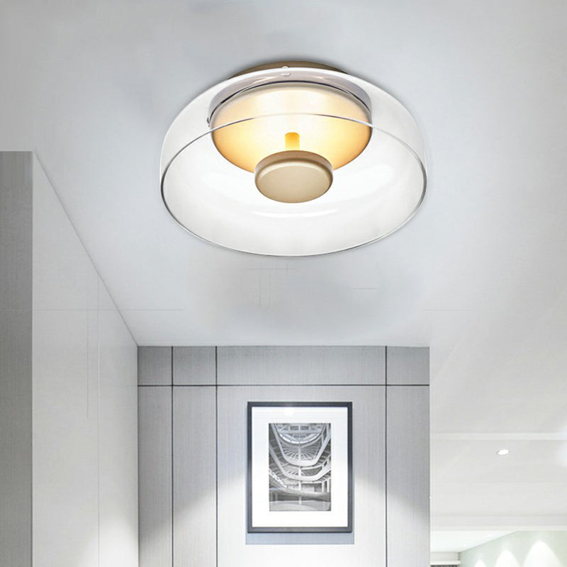 Clear glass flush light with a gold-toned centre disc, lit, above a hallway with framed picture 3