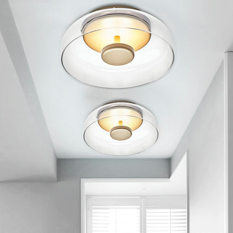 Large and small clear glass flush lights side by side on a pale hallway ceiling 4