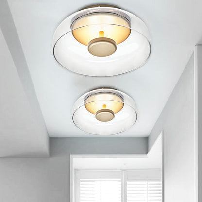 Large and small clear glass flush lights side by side on a pale hallway ceiling 4