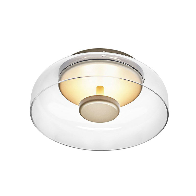 Close-up of the clear glass flush light on a white background, showing its glowing inner dome 5