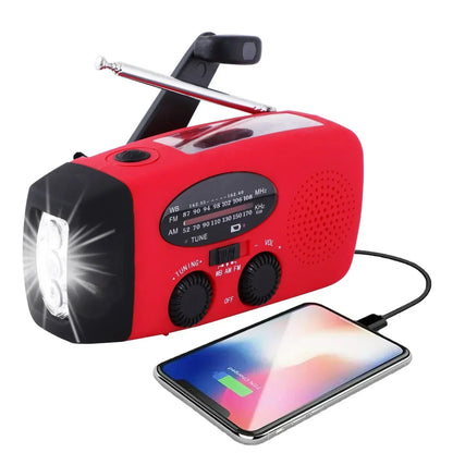 Red crank radio angled right with the torch lit, aerial extended and a phone charging 3