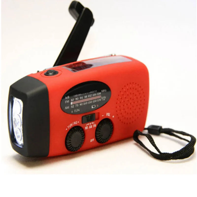 Red crank radio from the left, showing the folded handle, speaker grille and black wrist strap 2
