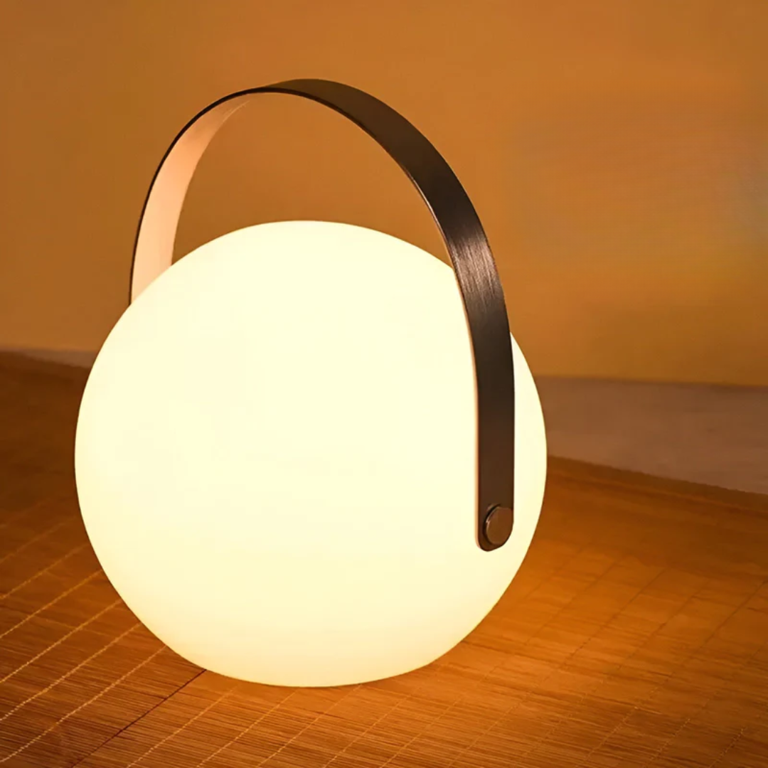 Globe lamp with black handle glowing warmly on a woven bamboo mat 15