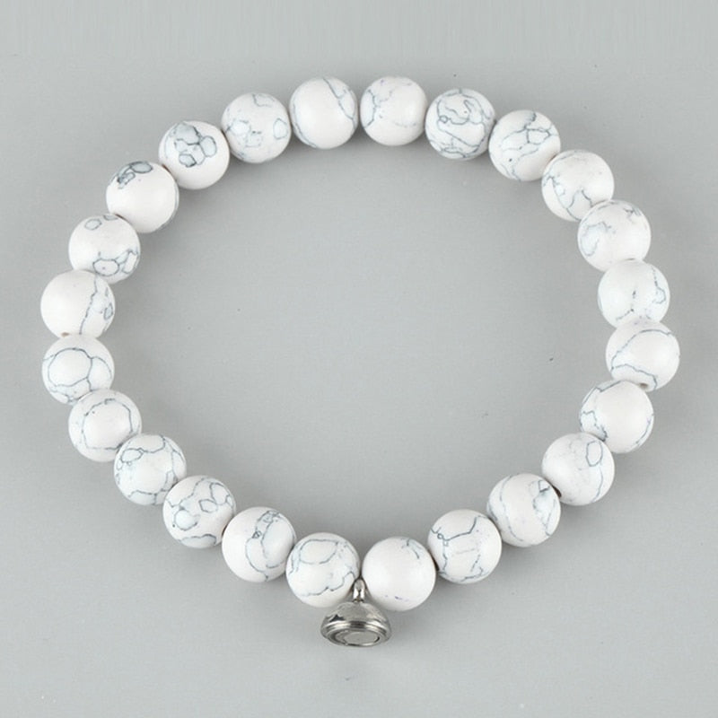 Flat lay of the white bracelet with grey marbled veining and a small silver magnetic clasp 3