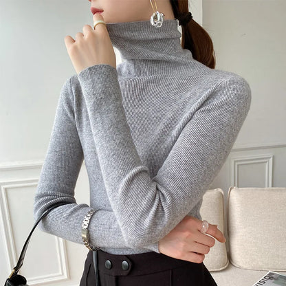 Model wearing the ribbed roll neck jumper in light grey with a silver watch and black trousers, seen from the side 7