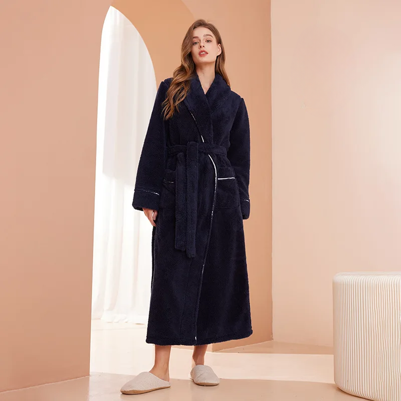 Model in a navy fleece robe with white piping, tied at the waist, beside an arched doorway 1