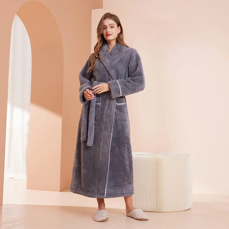 Model in a slate grey fleece robe, holding the belt at her waist, beside a pleated stool 11