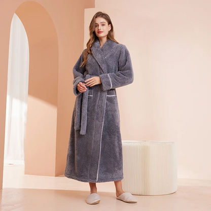 Model in a slate grey fleece robe, holding the belt at her waist, beside a pleated stool 11