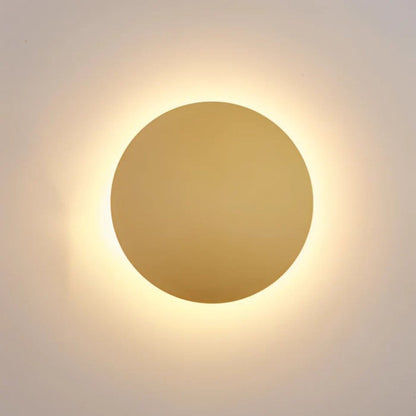 Close-up of the gold-coloured disc lit, with a soft warm halo glowing around its edge 1