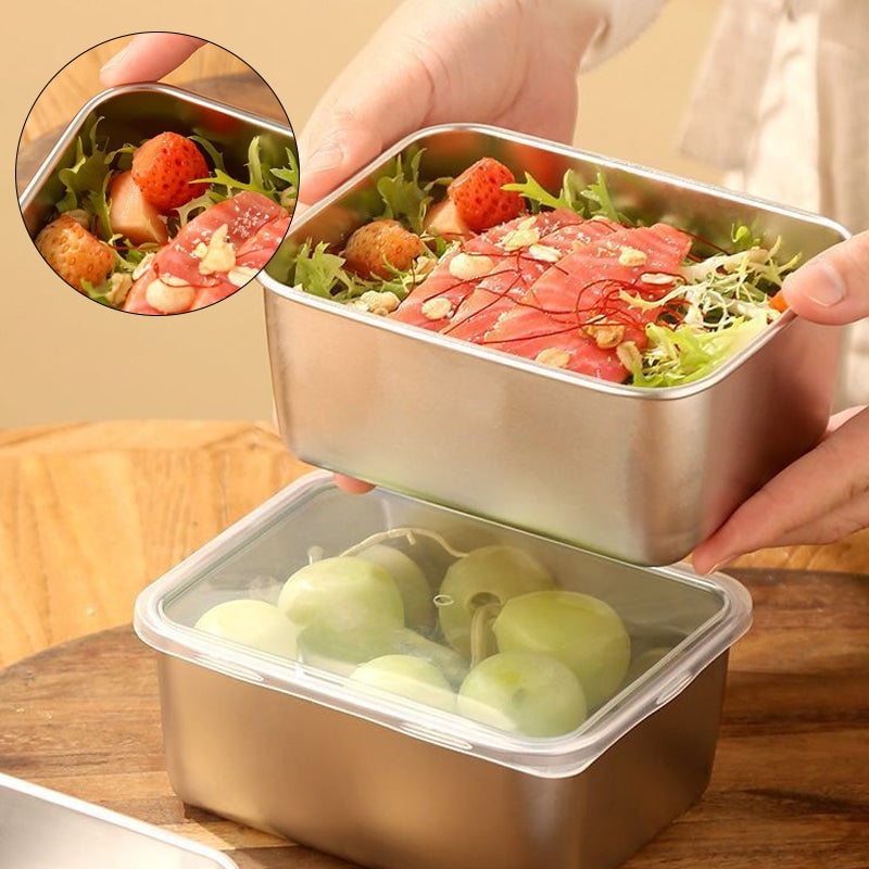 Hands lift a steel container of salad with salmon and strawberries above a lidded container of green grapes, with a close-up inset. 1