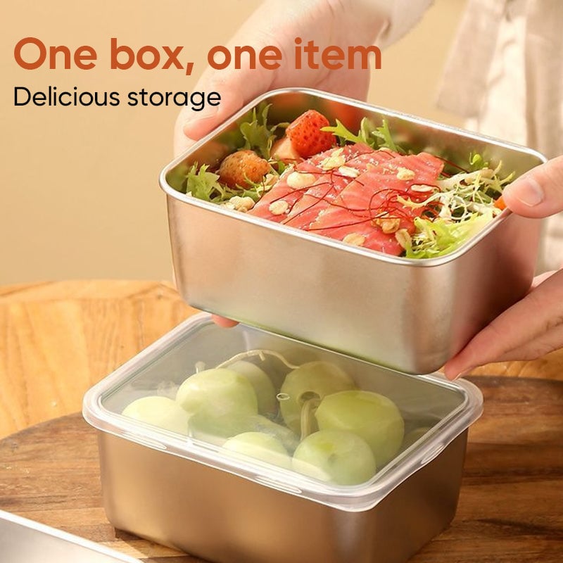 Hands holding a steel box of salad and salmon over a second box with a clear lid containing green grapes. 5