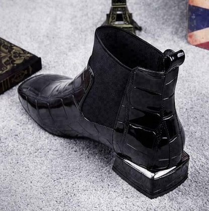 Rear three-quarter view of the black croc-effect ankle boot, showing the pull tab, textured heel counter and chunky block heel with metallic trim. 3