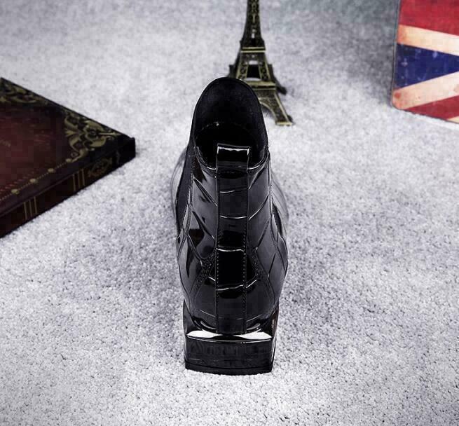 Straight-on back view of the black glossy ankle boot, showing the pull loop, croc-embossed leather and square block heel with silvery edge. 4